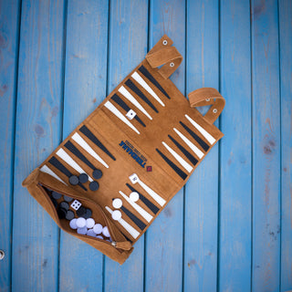 Teremana Backgammon-Set aufgeklappt auf blauem Holz, Wildleder braun mit Spielsteinen und Würfeln
